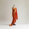 Vibrant colorful sari and lehenga set from CoutureMantra displayed on a hanger with intricate embroidery and traditional designs.