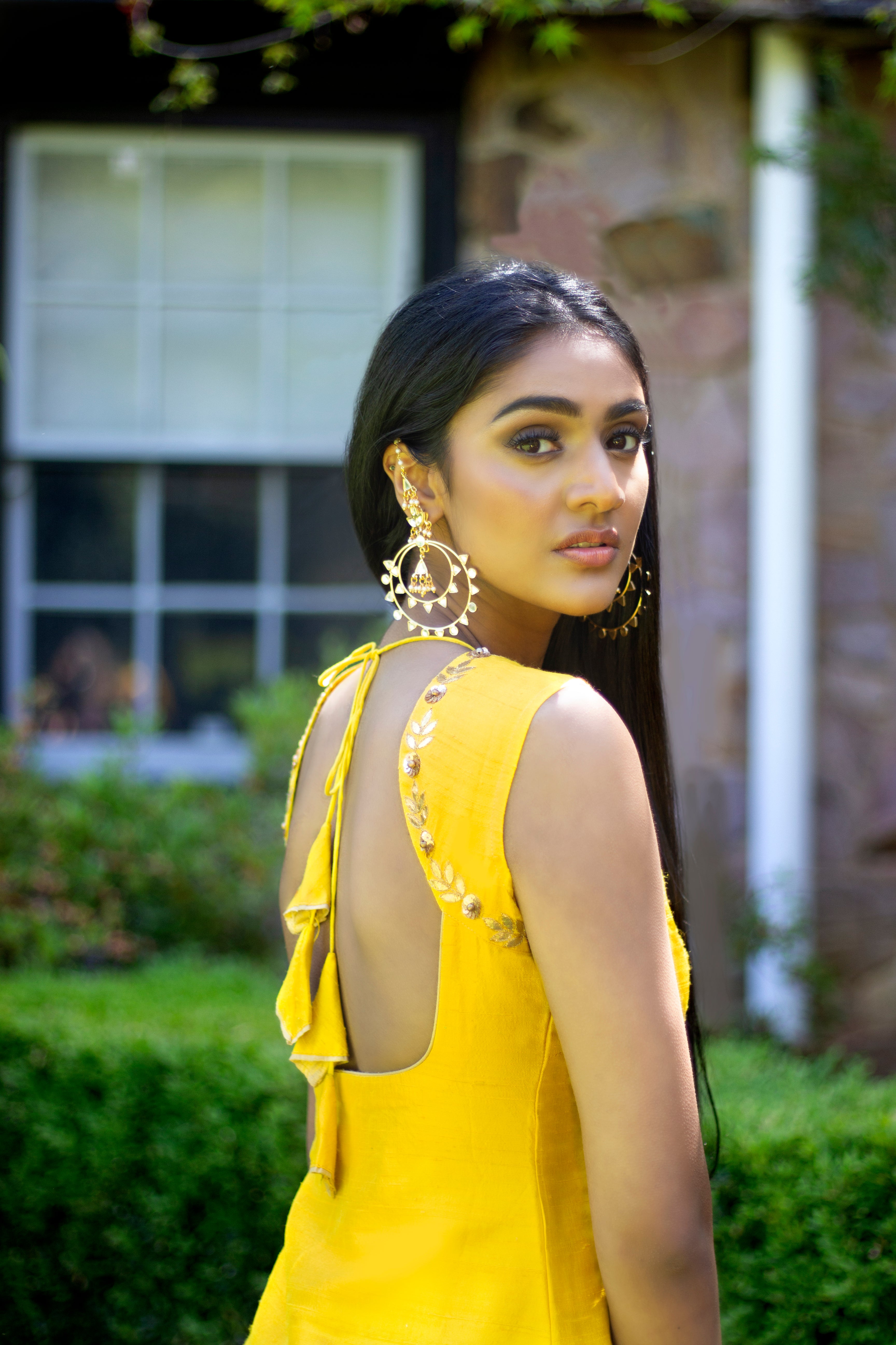 Yellow and pink Rani Gharara Sharara by Couture Mantra with intricate embroidery and flowing fabric, traditional Indian attire.