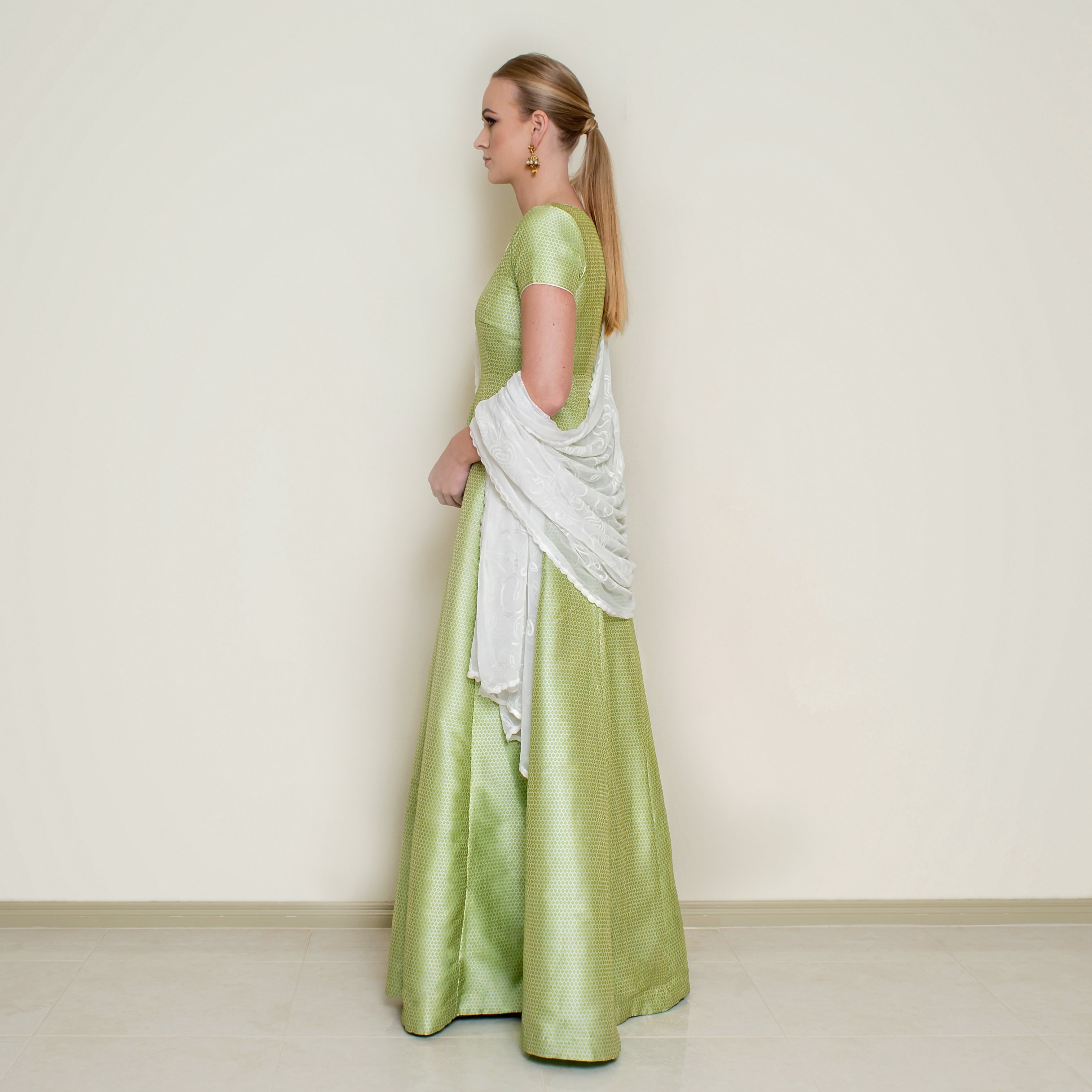 Green Bindi Anarkali dress by Nakir featuring traditional embroidery and flowing fabric, perfect for festive occasions.