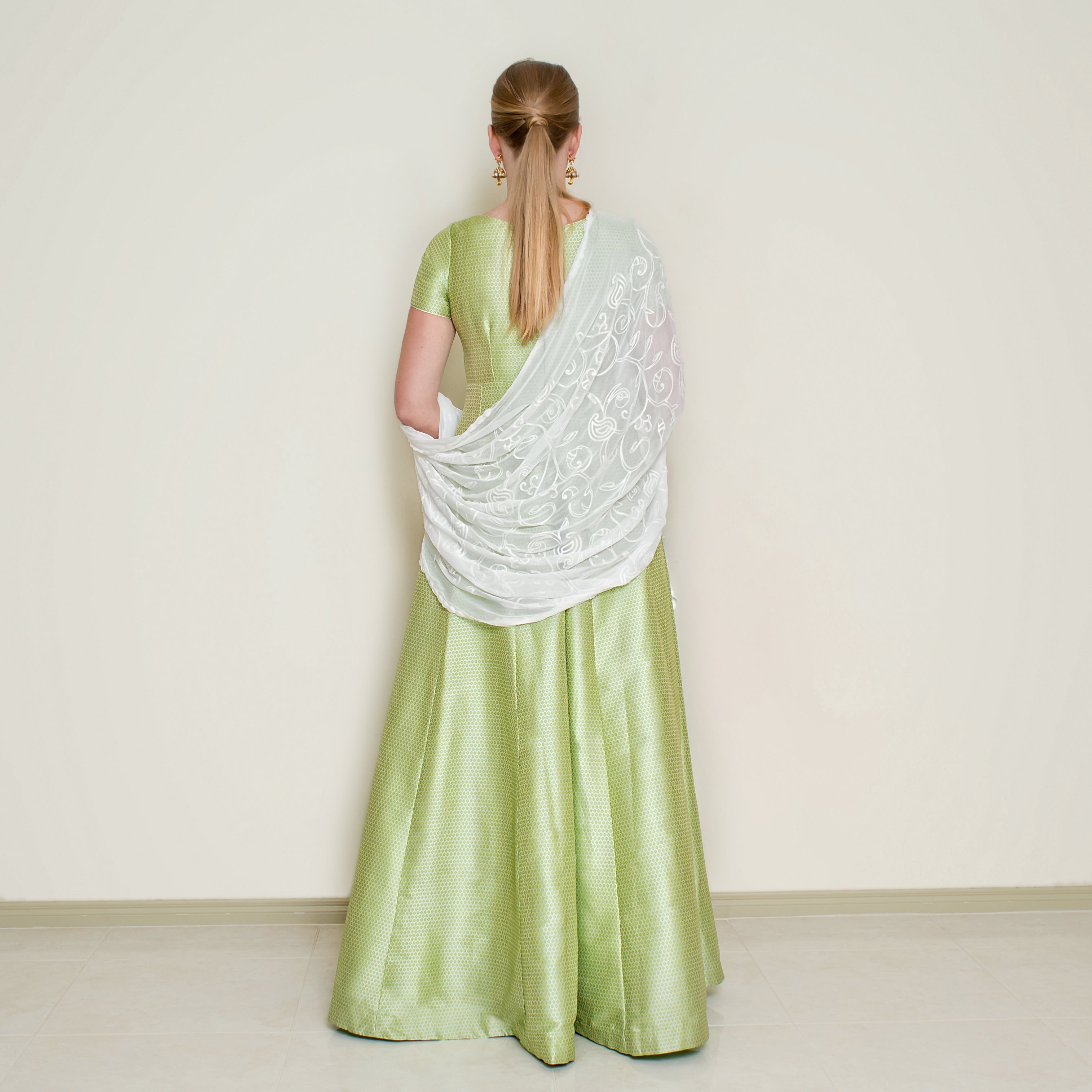 Green Bindi Anarkali dress by Nakir featuring intricate embroidery and flowing fabric, perfect for traditional celebrations.