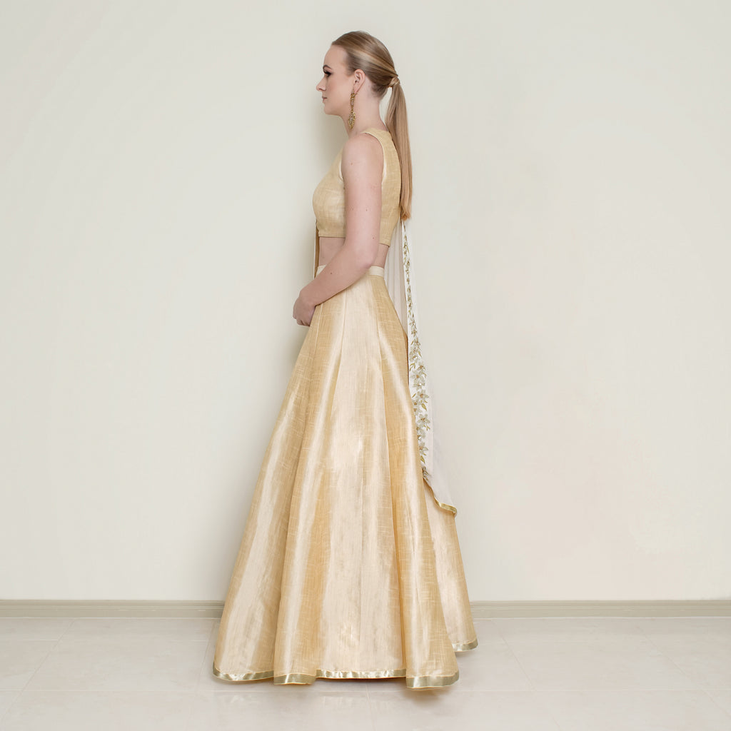 Nakir cream halter neck lehenga set with intricate embroidery, featuring a flowy lehnga and matching blouse for traditional weddings.