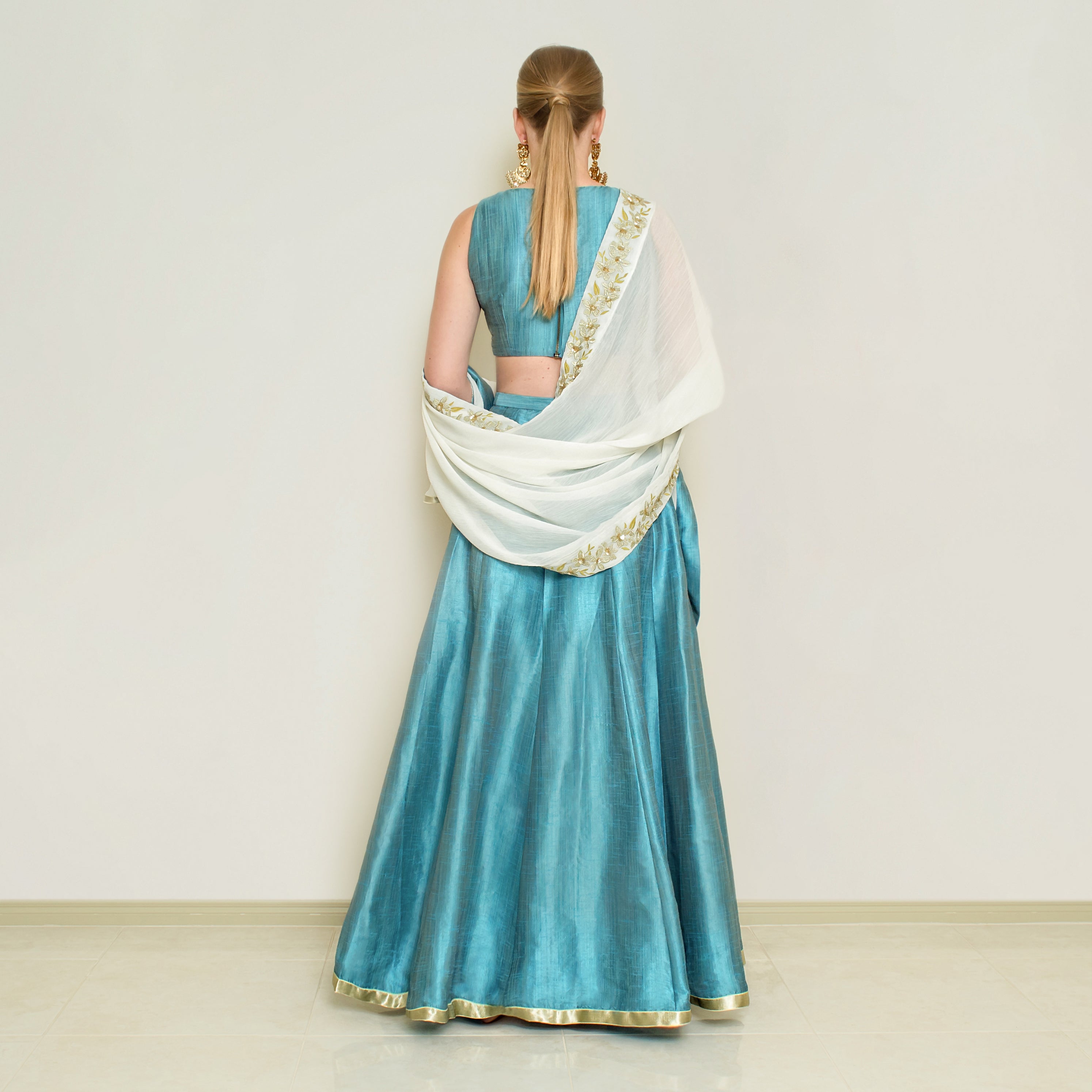 Blue halter neck lehenga set by Nakir featuring intricate embroidery and traditional design, perfect for festive occasions.