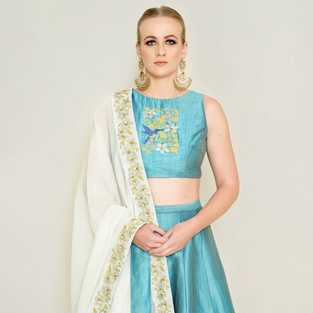 Blue halter neck lehenga set by Nakir featuring intricate embroidery and flowing fabric, perfect for festive occasions.