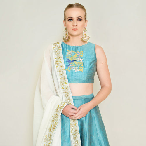Blue halter neck lehenga set by Nakir featuring intricate embroidery and flowing fabric, perfect for festive occasions.