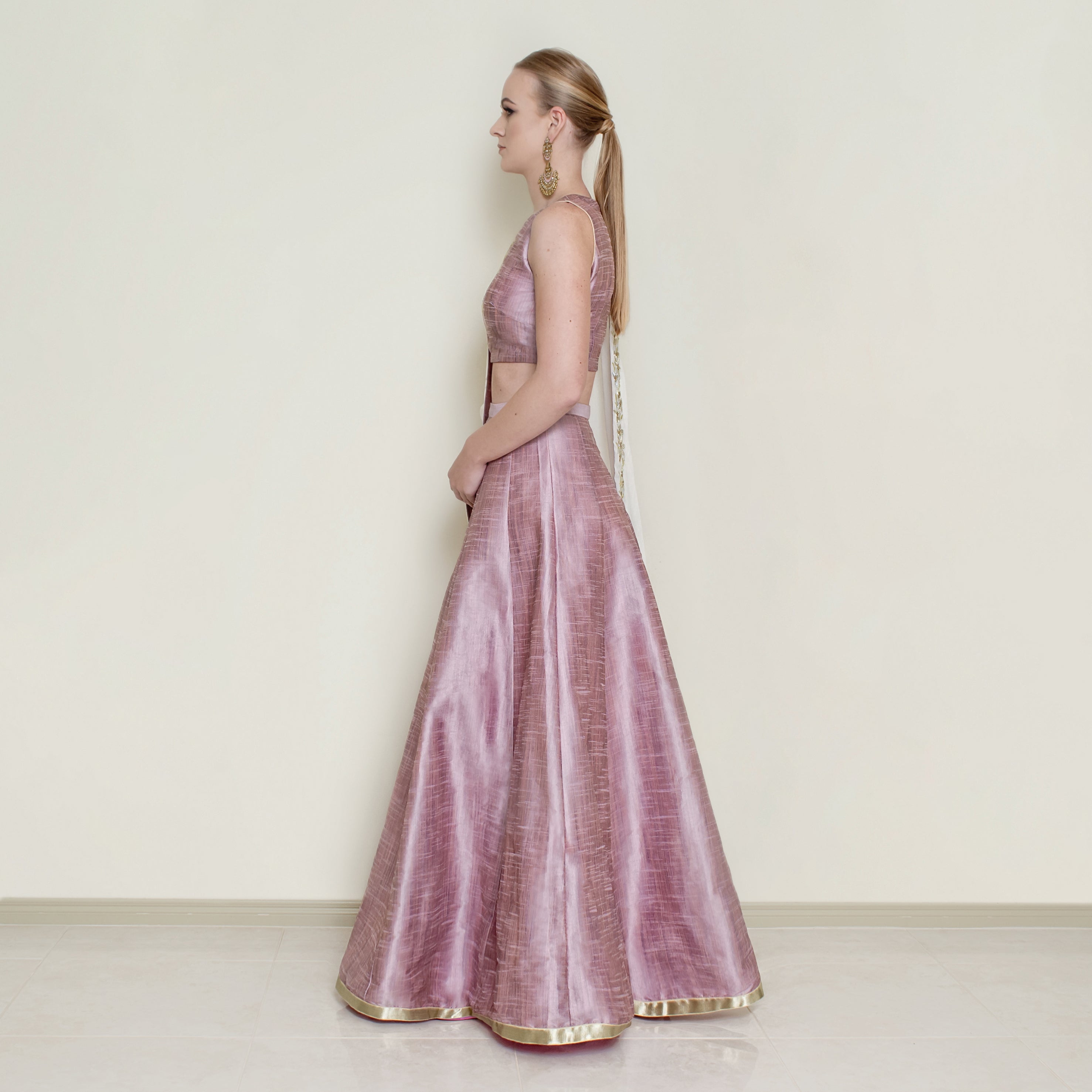 Pink halter neck lehenga set by Nakir featuring intricate embroidery and flowing fabric, perfect for traditional celebrations.