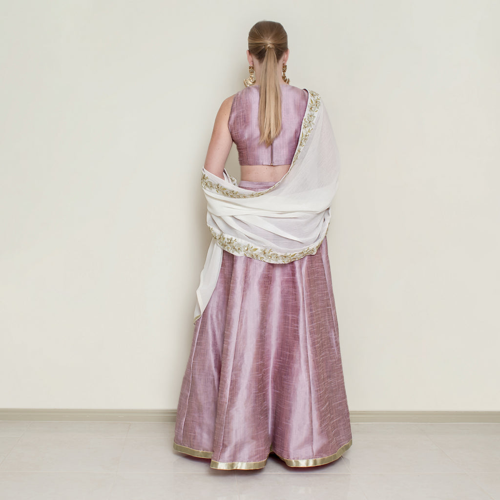 Pink halter neck lehenga set by Nakir featuring intricate embroidery and flowing fabric, perfect for traditional celebrations.