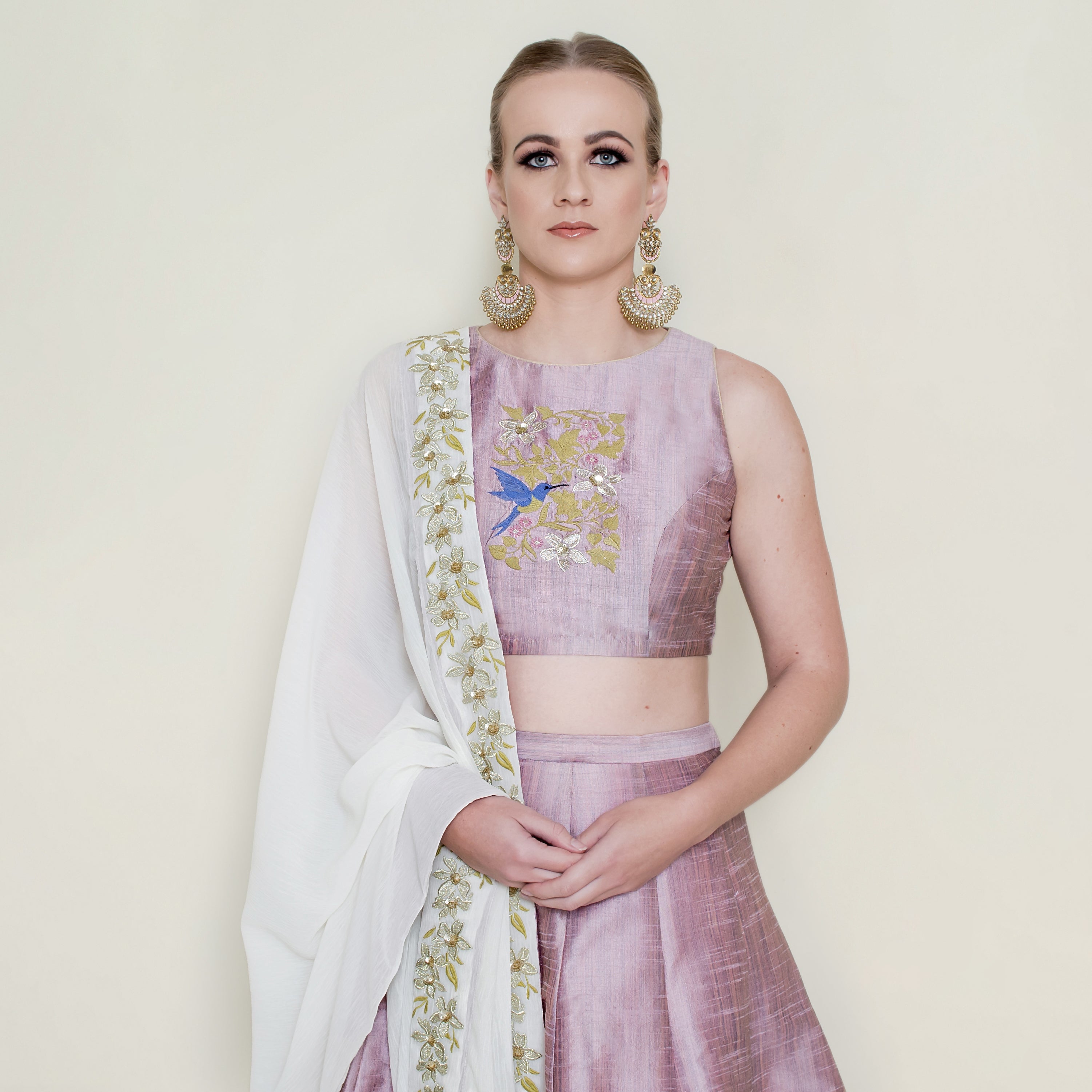 Pink halter neck lehenga set by Nakir featuring intricate embroidery and flowing fabric, perfect for festive occasions.