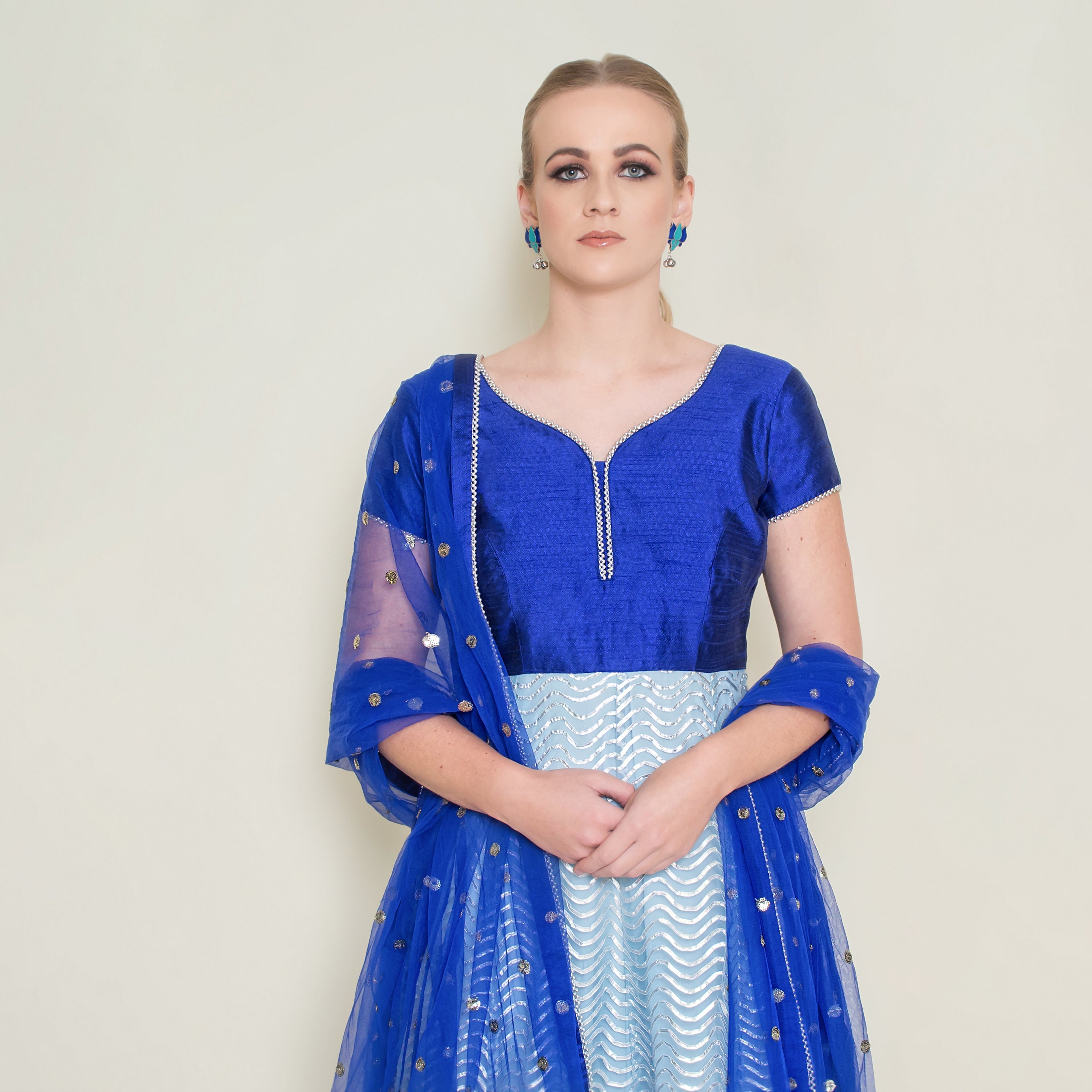 Powder blue Gotta Patti Anarkali dress by Nakir with intricate embroidery and flowing fabric, displayed on a hanger.