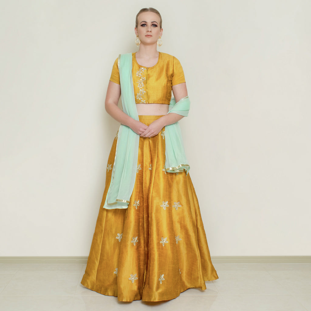 Nakir mustard pineapple lehenga set with intricate embroidery, featuring a matching blouse and flowing skirt for festive occasions.