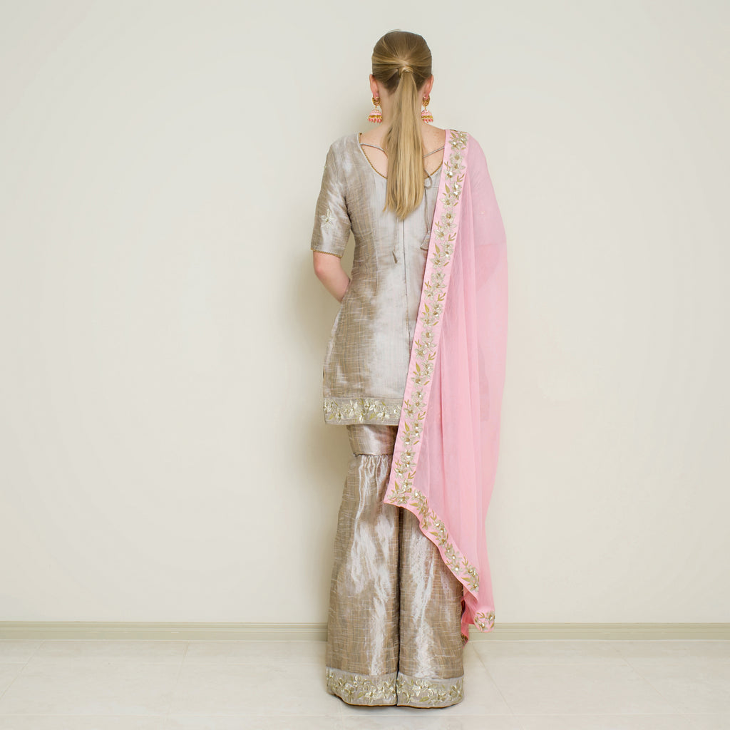 Stone grey embroidered Sharara set by Nakir, featuring intricate embroidery and traditional design on flowing fabric.
