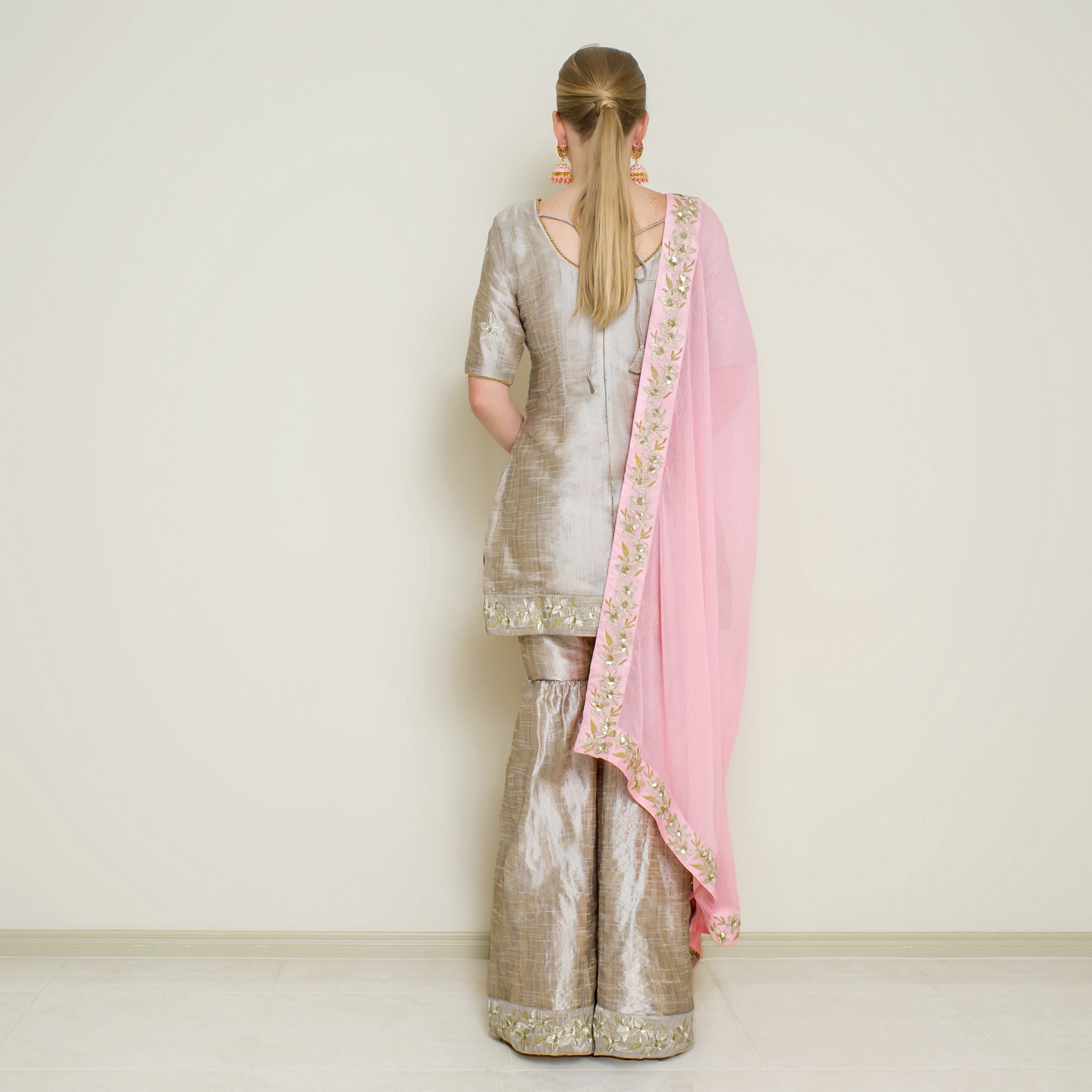 Stone grey embroidered Sharara set by Nakir, featuring intricate embroidery and traditional design on flowing fabric.