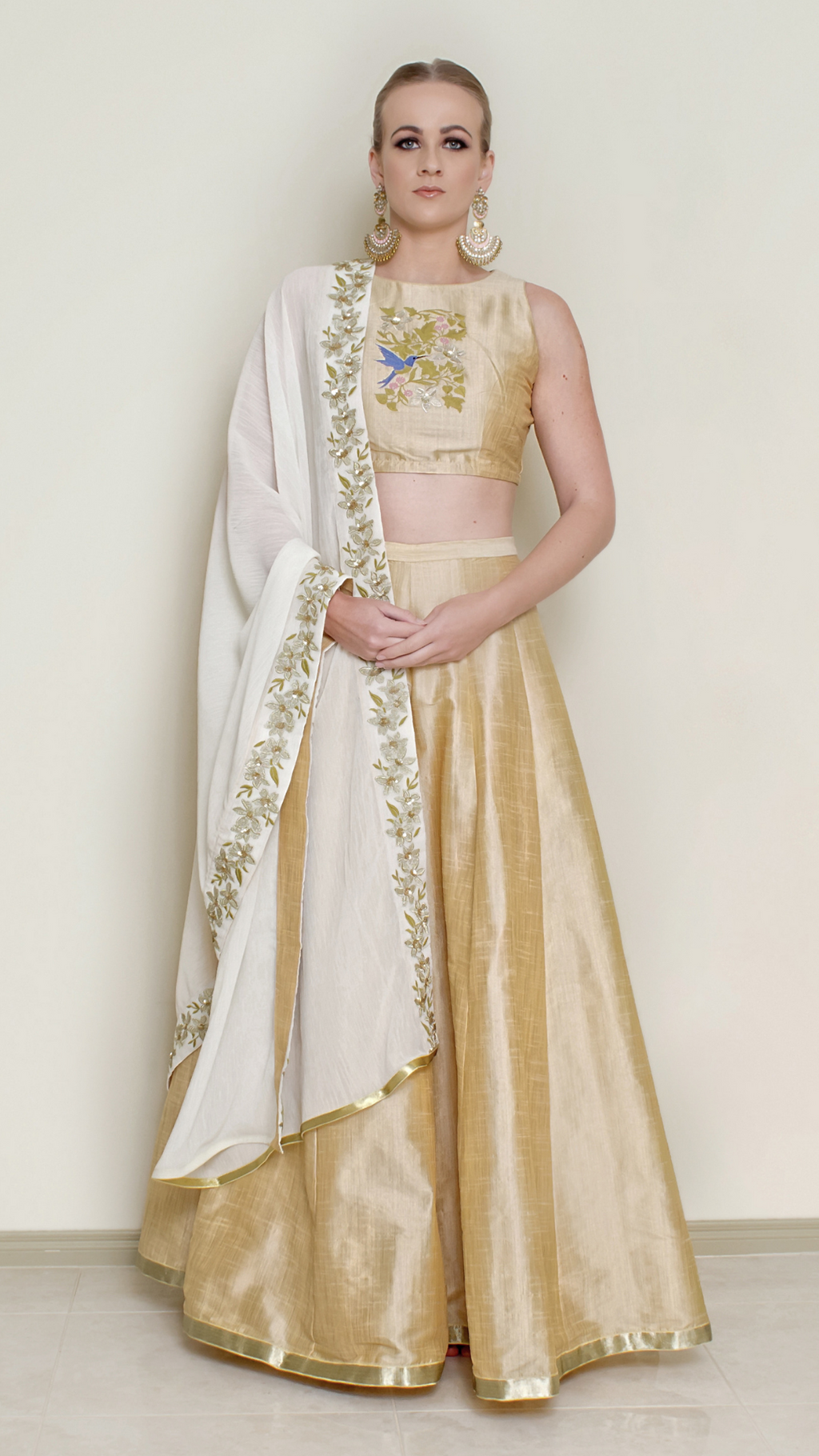 Cream halter neck lehenga set by Nakir featuring intricate embroidery and traditional design, perfect for festive occasions.