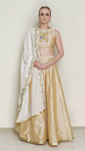 Cream halter neck lehenga set by Nakir featuring intricate embroidery and traditional design, perfect for festive occasions.
