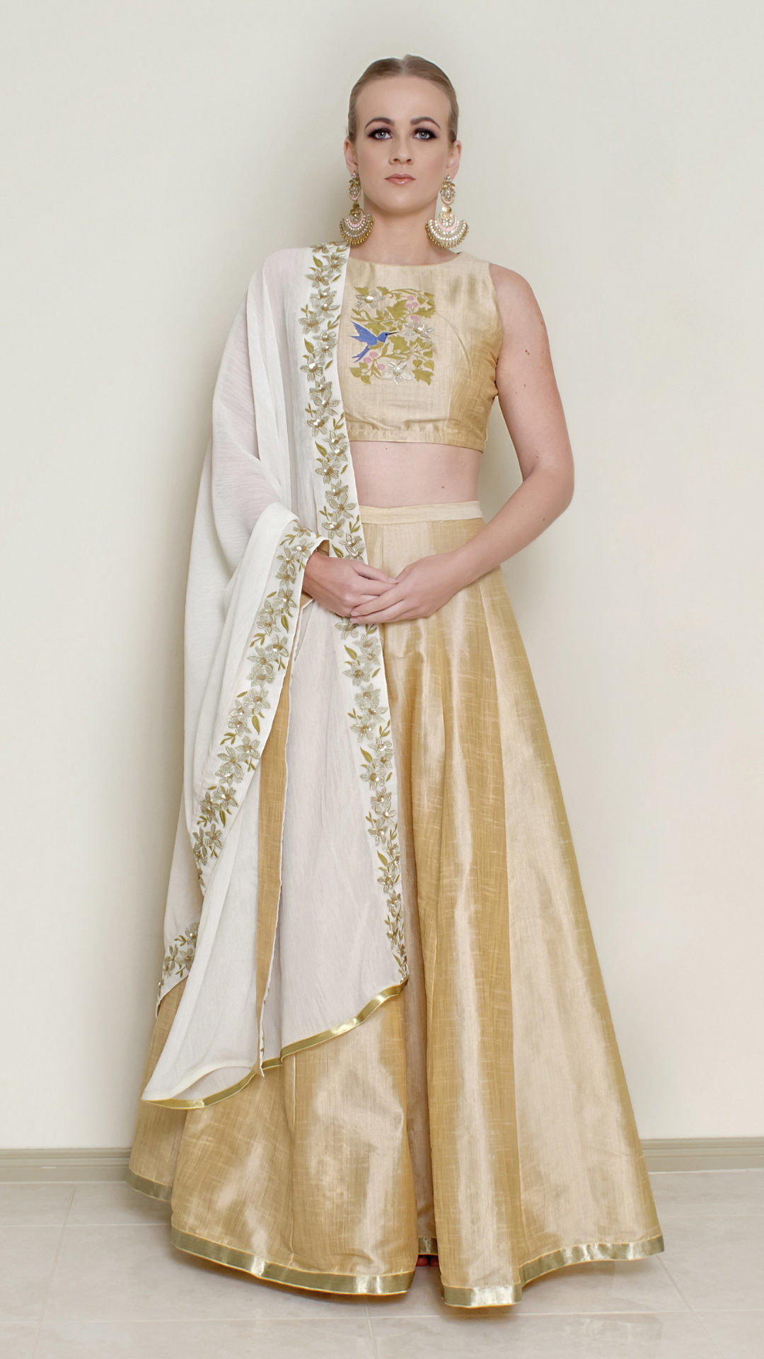 Cream halter neck lehenga set by Nakir featuring intricate embroidery and traditional design, perfect for festive occasions.