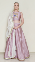 Pink halter neck lehenga set by Nakir featuring intricate embroidery and flowing fabric on a traditional Indian lehnga.